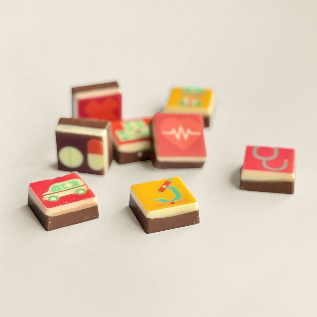 Bedruckte Schokoladenwürfel aus Milch- und weißer Schokolade, einzeln verpackt als Geschenk für Mitarbeiter, Geschäftspartner oder zum Tag der Pflege. Tasty Present – personalisierte Schokolade und Süßigkeiten