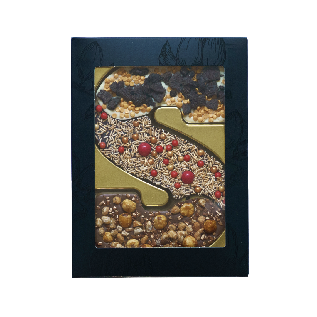 Signature Blends chocoladeletter S Festive Mix met witte, melk- en pure chocolade, Oreo, hazelnoten, chocoladeballetjes en opvallende rode topping in zwarte vensterdoos met gouden tray. Tasty Present - gepersonaliseerde chocolade en snoep