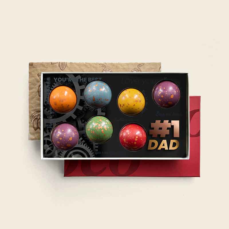Luxuriöse Geschenkverpackung mit 7 handgefertigten #1 DAD XL Dome-Pralinen in verschiedenen überraschenden Geschmacksrichtungen, speziell zusammengestellt als einzigartiges Vatertagsgeschenk für Papa. Tasty Present – personalisierte Schokolade und Süßigkeiten