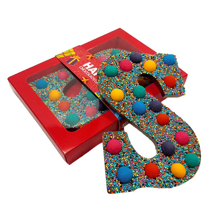 „Happy Truffel“-Schokoladenbuchstaben in bunten Farben in einer luxuriösen roten Geschenkbox